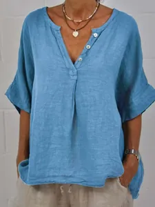 Detail view of blue cotton linen V-neck shirt with loose fit and buttons