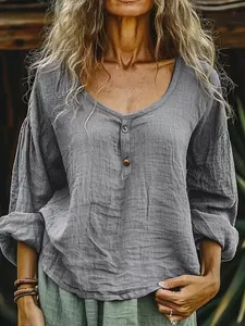 Vista detallada de la blusa de lino gris con cuello redondo y botones decorativos