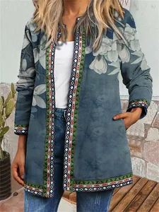 Detailed view of the vintage ethnic floral print and geometric trim on this teal cardigan.