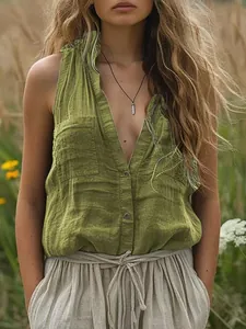 Detail of a moss green sleeveless cotton linen shirt with chest pockets and V-neckline