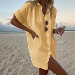 Camisa holgada de algodón y lino amarillo con manga corta para mujer en la playa al atardecer