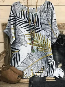 Close-up detail of casual loose short-sleeved top featuring tropical gold leaf prints