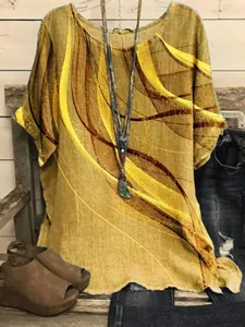 Close-up detail of loose women's tunic with yellow wavy graphic print on linen texture.