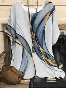 Detailed view of women's loose round neck top with abstract blue and gold print