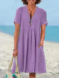Detail view of a loose-fitting purple V-neck cotton linen dress with pleated front