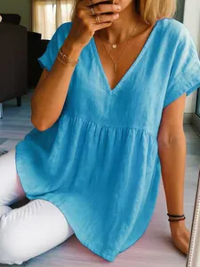 Close-up of a bright blue casual V-neck cotton linen top with ruffled waist detail.