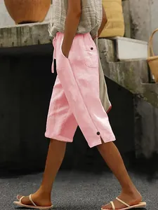 Détail d'un pantalon en coton et lin rose avec taille à cordon et poches latérales utiles