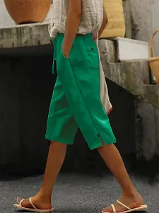 Vue latérale du pantalon court en coton et lin vert avec poches et cordon de serrage