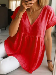 Close-up of red cotton linen V-neck top with pleated waist detail