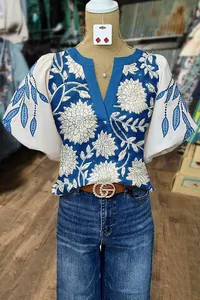 Vue détaillée de l'imprimé floral ethnique et des manches lanterne de cette blouse bleue à col en V