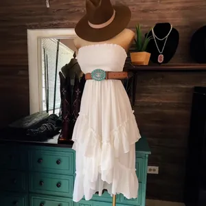 Elegant boho style white strapless ruffled tiered beach midi dress on a mannequin