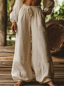 Close-up detail of off-white wide-leg linen pants featuring elastic drawstring waist and pockets