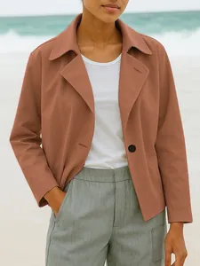 Close-up of a terracotta short blazer jacket styled with white tee and grey trousers