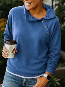 Detailed shot of women's blue sweatshirt with stylish diagonal button collar design.