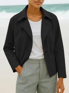 Detail view of a black short casual blazer jacket for women in a stylish outdoor setting