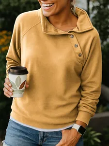 Detail of mustard yellow sweatshirt with asymmetrical button neck and raglan sleeves
