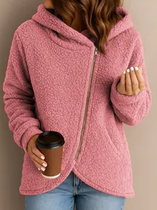 Close-up of pink teddy fleece hoodie featuring an asymmetrical zipper and soft texture