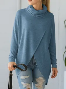 Detailed view of woman wearing a blue cowl neck knit top with asymmetric wrap hem design