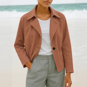 Chic women's short terracotta blazer jacket, stylish fall casual coat on a beach.