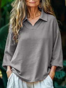 Detailed view of women's loose grey long-sleeved polo shirt with a turn-down collar