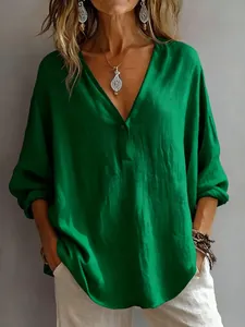 Detail view of the green V-neck blouse showing textured fabric and loose fit