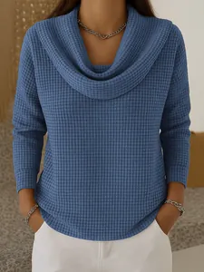 Gros plan d'un pull bleu en maille gaufrée avec un col bénitier élégant