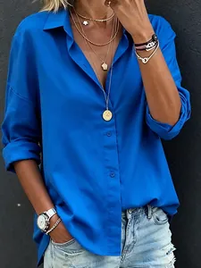 Detailopname van koningsblauwe blouse met lange mouwen en elegante sieradenaccessoires
