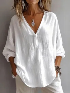 Close-up detail of a white v-neck long sleeve loose linen-style blouse for women