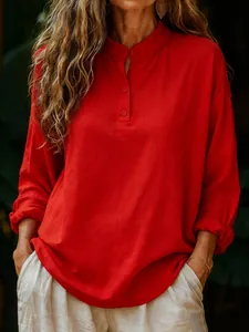 Detailed view of women's loose red long-sleeve cotton blouse with buttoned collar