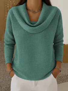 Détail d'un haut bleu sarcelle en maille gaufrée avec col bénitier élégant pour femme
