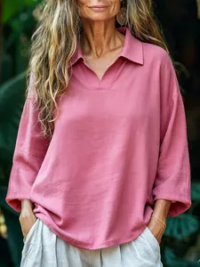 Detail of loose-fitting pink polo blouse featuring natural cotton-linen texture and V-neck