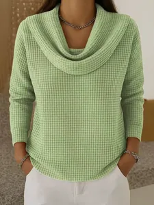 Vue détaillée de la texture en maille gaufrée verte et du col bénitier de ce haut pour femmes.