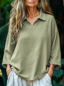 Detailed view showing the casual loose fit of a sage green collared linen shirt
