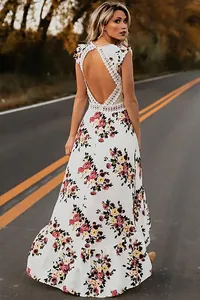Détail d'une robe fleurie blanche montrant le dos nu avec dentelle et ourlet en queue de pie