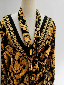 Detail view of the intricate retro gold baroque print on black V-neck long sleeve maxi dress