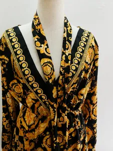 Detail view of the intricate retro gold baroque print on black V-neck long sleeve maxi dress