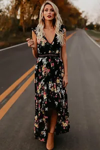 Détail d'une robe longue fleurie de style bohème avec col en V et ourlet irrégulier.