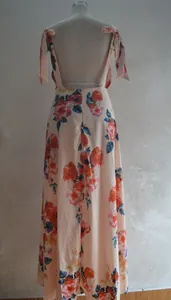 Elegant bohemian backless floral maxi dress featuring tie straps and a vibrant orange rose print