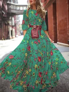 Close-up detail of a bohemian green floral maxi dress with red belt and small pouch.