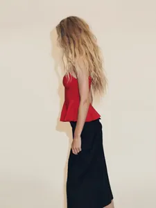 Haut caraco rouge élégant à basque assorti avec un pantalon noir pour un look chic d'été