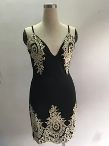 Détail de la broderie en dentelle complexe sur une mini-robe noire moulante à col en V