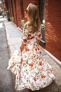 Detailed view of bohemian floral maxi dress with three-quarter sleeves and belt in urban street