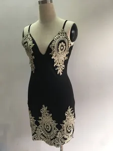 Détail de l'applique en dentelle dorée sur une robe courte noire sexy à col en V