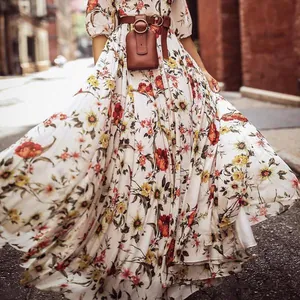 Close-up of bohemian floral print maxi dress with brown leather belt and small pouch