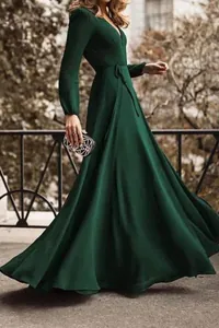 Vista lateral de un elegante vestido largo verde esmeralda con cuello en V y manga larga