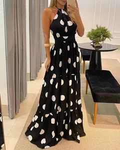 Full length elegant black and white polka dot halter maxi dress with flowing tiered skirt