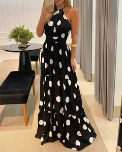 Elegant black halter neck maxi dress featuring white polka dots and a tiered skirt design
