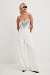 Model wearing a black and white striped cotton tube top paired with white trousers