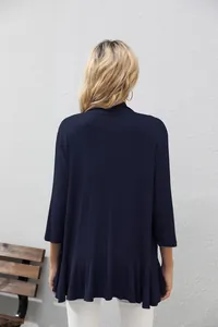Detalle de la espalda y el bajo con volantes de este cárdigan de punto azul marino