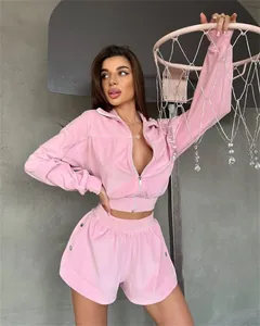 Detailed view of pink velvet zip-up jacket and shorts set with white piping